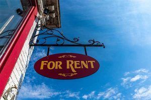 A for rent sign hangs on a building